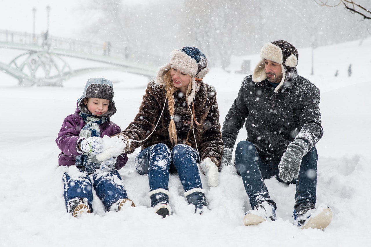 woman-man-and-girl-sitting-on-snow-1620653
